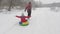 Happy dad is lucky on a sled along the snow-white road of a child. Christmas holidays and travel. A fun game for adults