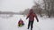 Happy dad rides a child on a sled on a white snowy road. Christmas Holidays. A fun game for adults and children. The