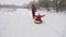 Happy dad sledges a child on a snowy road. Christmas Holidays. father plays with his daughter in a winter park. The