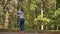Happy Dance Of Beautiful Caucasian Brunette Girl Who Is Artistically Moving Backward In Sunny Park on Trees Background