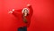 Happy dancing girl in headphones and Christmas clothes on a red background. Fun holiday playlist