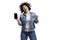 Happy dancing young beautiful girl in jeans shows a smartphone that is emitted on a black screen. Bright brunette with curly hair