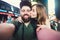 Happy dating couple in love taking selfie photo on Times Square in New York while travel in USA on honeymoon