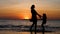 Happy daughter and mother silhouette dance on dramatic sunset