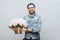 Happy delighted male buys bouquet of flowers for special occasion, wears denim jacket and denim shirt, isolated over white