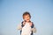 Happy delightful laughing little child in sweater on blue sky background