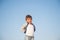 Happy delightful smiling little boy in sweater on blue sky background