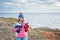 Happy delightful smiling pretty young female in wool hat and track suit holding two small dressed in animal clothes chihuahua dogs