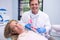 Happy dentist holding dental mould by woman at medical clinic