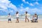 Happy disabled senior elderly woman in wheelchair spend time together with family on tropical beach. Asian grandma, daughter,