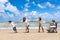 Happy disabled senior elderly woman in wheelchair spend time together with family on tropical beach. Asian grandma, daughter,