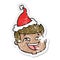 happy distressed sticker cartoon of a male face wearing santa hat