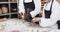 Happy diverse bakers working in bakery kitchen, making rolls from dough in slow motion