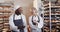 Happy diverse bakers working in bakery kitchen, using smartphone in slow motion