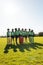 Happy diverse children collecting recycling embracing in sunny elementary school field, copy space