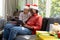 Happy diverse couple in christmas hats having tablet video call smiling in sunny living room