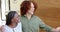 Happy diverse couple greeting friends at front door of home, slow motion