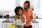 Happy diverse couple in kitchen smiling and embracing