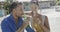 Happy diverse couple talking and drinking beers on beach sun deck, in slow motion