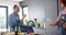 Happy diverse couple wearing aprons drinking wine and preparing meal in kitchen, slow motion