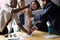 Happy diverse employees stack fists at corporate meeting, celebrating success