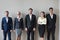 Happy diverse executives team standing near wall headshot portrait