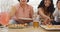 Happy diverse female friends sitting on sofa in living room, eating pizza