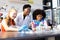 Happy diverse female teacher and two schoolgirls doing experiment in chemistry class