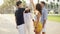 Happy diverse friends greeting each other outdoors on alley with palm trees