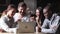 Happy diverse friends watching music video dancing sit at table