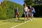 Happy diverse group of friends arriving together at tennis court