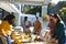 Happy diverse male and female friends serving thanksgiving celebration meal in sunny garden