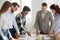 Happy diverse team brainstorm in office with papers on table