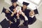 Happy diverse university graduates in traditional academic hats celebrating graduation