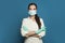 Happy doctor or nurse woman in protective medical mask and surgical gloves on blue background.  Medicine, assistance, safety and