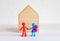 Happy doll family in front of wooden house. Family home, Insurance idea
