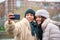 Happy dominican lesbian couple taking a selfie with phone at street in winter.