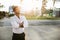 Happy dreamy european businessman in formal wear standing outdoors with folded arms and looking away at empty space