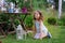 Happy dreamy kid girl playing in summer garden, decorated with lantern light and candle