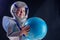 Happy dressed costume astronaut girl holding world globe on a black background in the studio