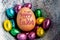 Happy Easter 2017 lettering on egg lined with small chocolate eggs wrapped in colorful foil.