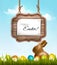 Happy Easter background with chocolate rabbit and wooden sign.