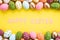 Happy easter! Close Up Colorful Easter eggs on yellow paper background. Happy family preparing for Easter