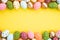 Happy easter! Close Up Colorful Easter eggs on yellow paper background. Happy family preparing for Easter