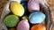 Happy Easter. Close up of painted eggs in a basket rotating in circle. POV.