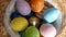 Happy Easter. Close up of painted eggs in a basket rotating in circle. POV.