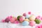 Happy easter! Colorful of Easter eggs in nest with flower and Feather on white cheesecloth background