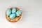 Happy easter composition. Nest with blue pained easter eggs. Texture rustic white wooden background. Flat lay, top view and copysp