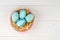 Happy easter composition. Nest with blue pained easter eggs. Texture rustic white wooden background. Flat lay, top view and copysp