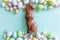 Happy Easter concept. Easter candy chocolate eggs bunny and jellybean sweets isolated on trendy pastel blue background. Simple